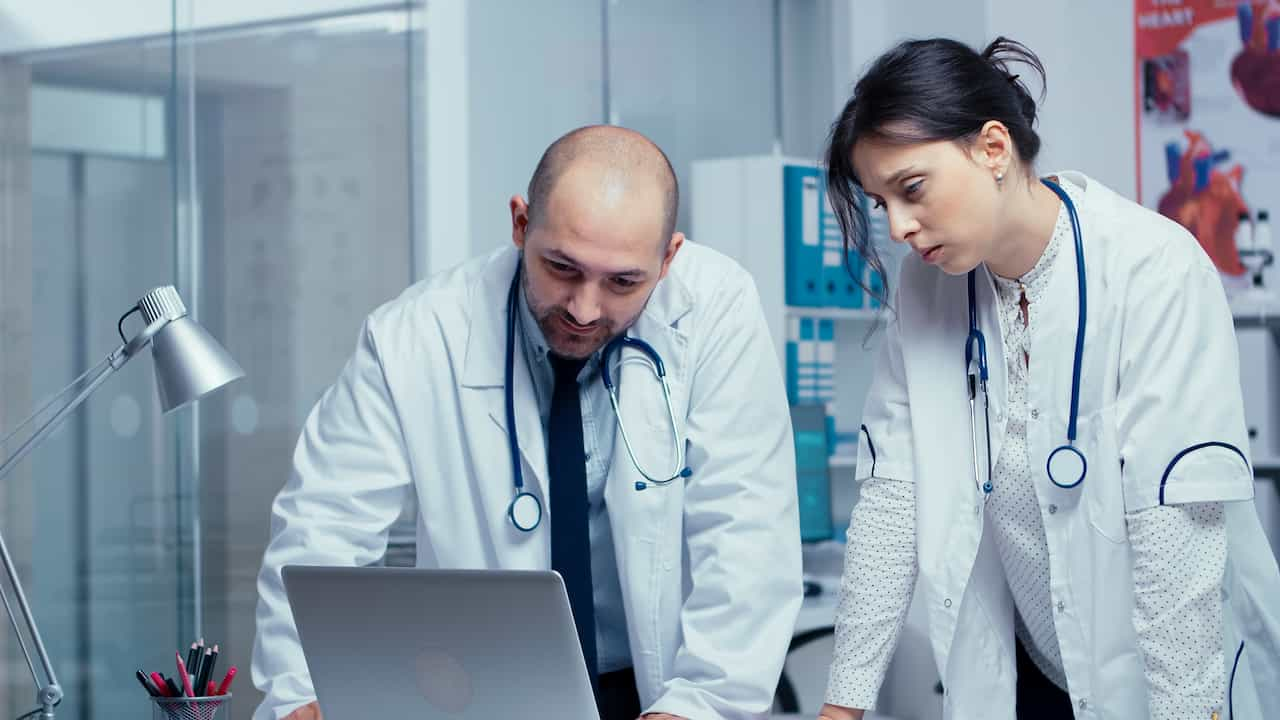 médicos analisam sistemas hospitalares